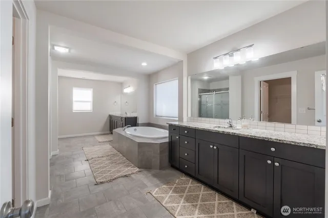 a large bathroom with a granite countertop tub sink and mirror