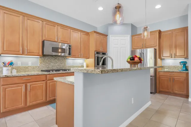 a kitchen with stainless steel appliances granite countertop a sink a stove and a refrigerator