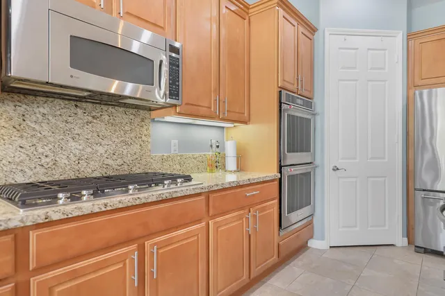 a kitchen with stainless steel appliances granite countertop a refrigerator and cabinets