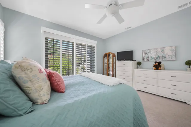 a bedroom with a bed and a large window