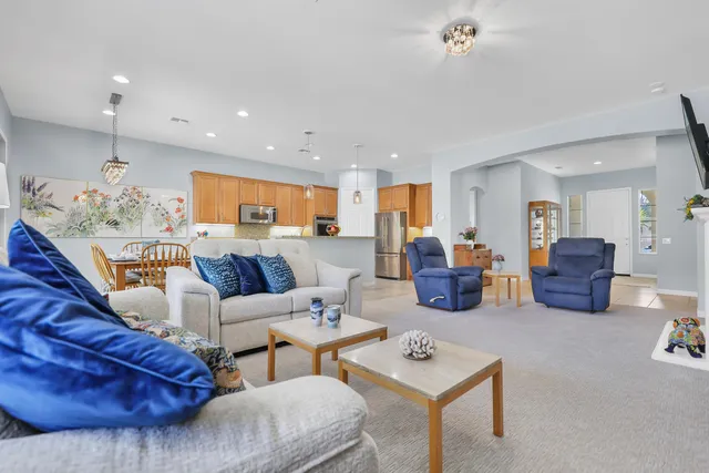 a living room with furniture kitchen view and a table