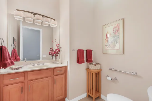 a bathroom with a sink vanity mirror and toilet