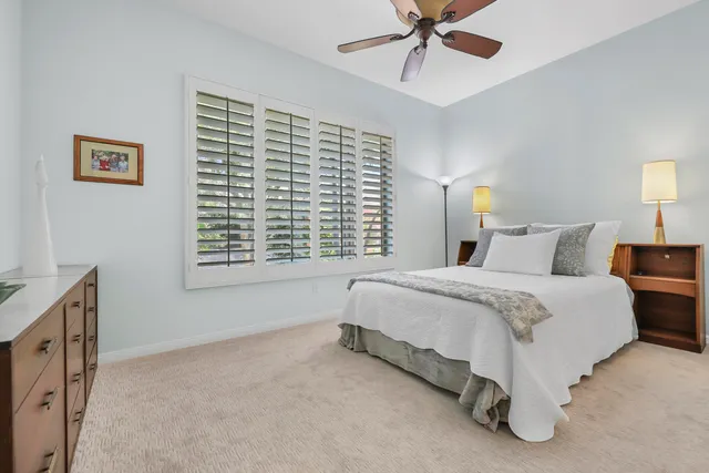 a spacious bedroom with a bed and a chandelier