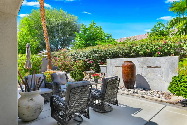 a view of a backyard with furniture and a garden