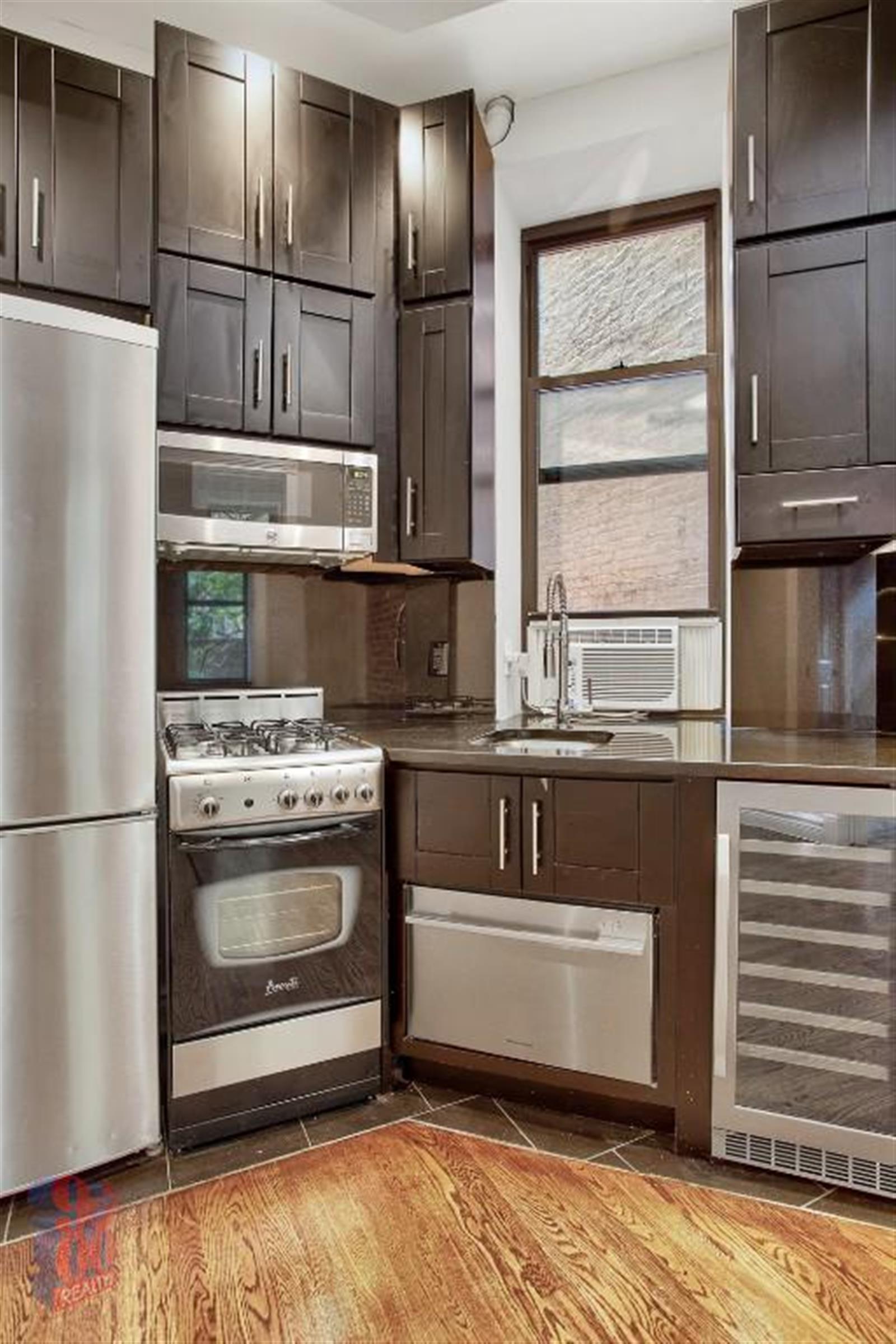 246 Mott Street, Unit 7 Manhattan, NY 10012 - Photo 3 of 6 a kitchen with a refrigerator and a view of living room
