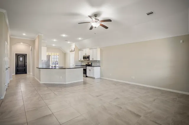 a living room with furniture and view of kitchen