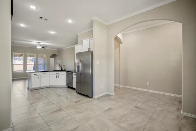 a view of a kitchen with refrigerator and window