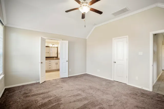 an empty room with a ceiling fan and carpet