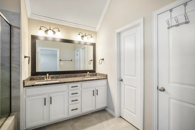 a bathroom with a granite countertop shower sink a mirror and a shower