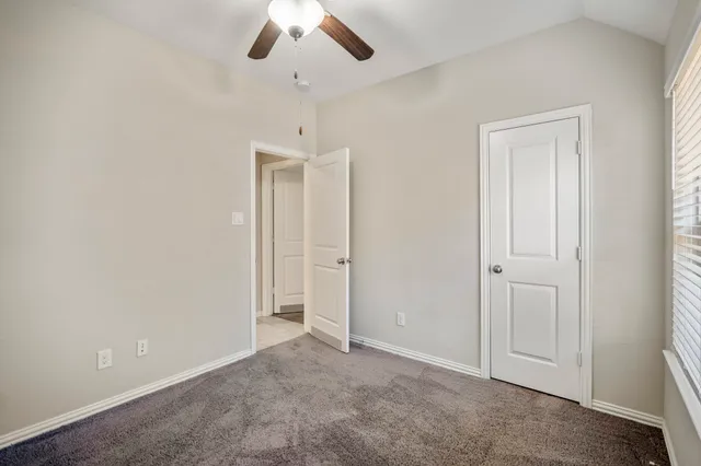 a bedroom with a ceiling fan and a bed