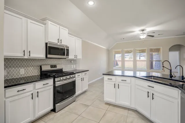 a kitchen with a sink stove and microwave