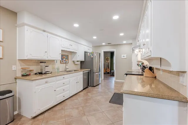 a large kitchen with kitchen island a sink stainless steel appliances and cabinets