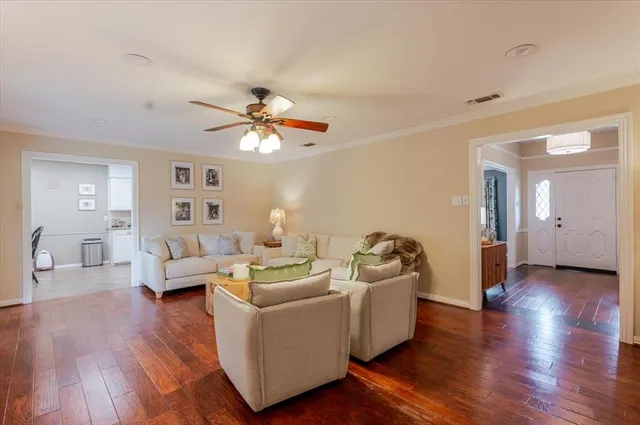 a living room with furniture and wooden floor