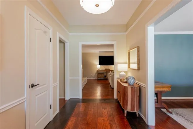 a view of a hallway view with living room and wooden floor