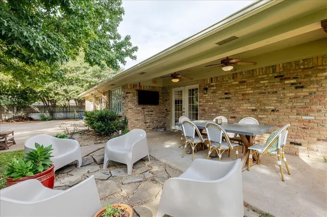 a roof deck with table and chairs potted plants and a large tree