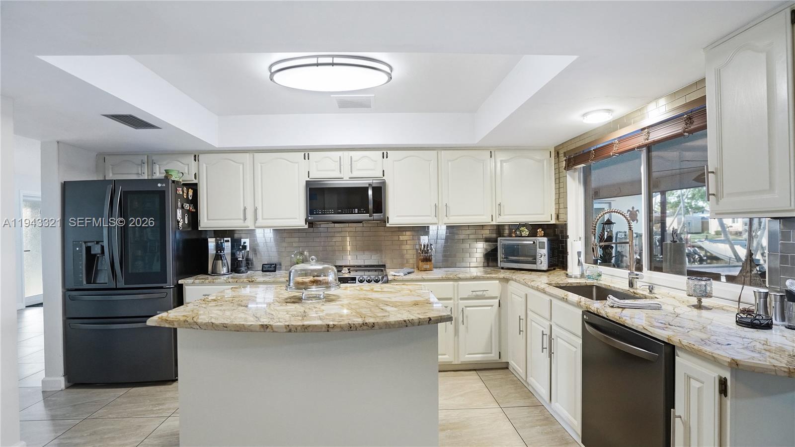 5921 Southwest 17th Street Plantation, FL 33317 - Photo 13 of 53 a kitchen with a sink stainless steel appliances and white cabinets