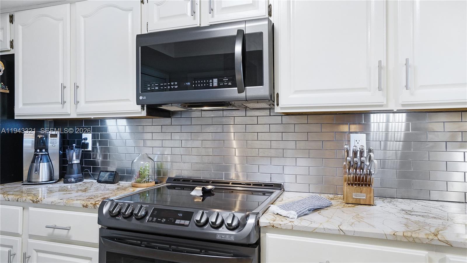 5921 Southwest 17th Street Plantation, FL 33317 - Photo 16 of 53 a kitchen with granite countertop a stove and a sink