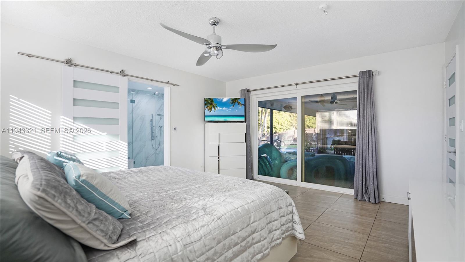 5921 Southwest 17th Street Plantation, FL 33317 - Photo 19 of 53 a bedroom with a bed and a large window