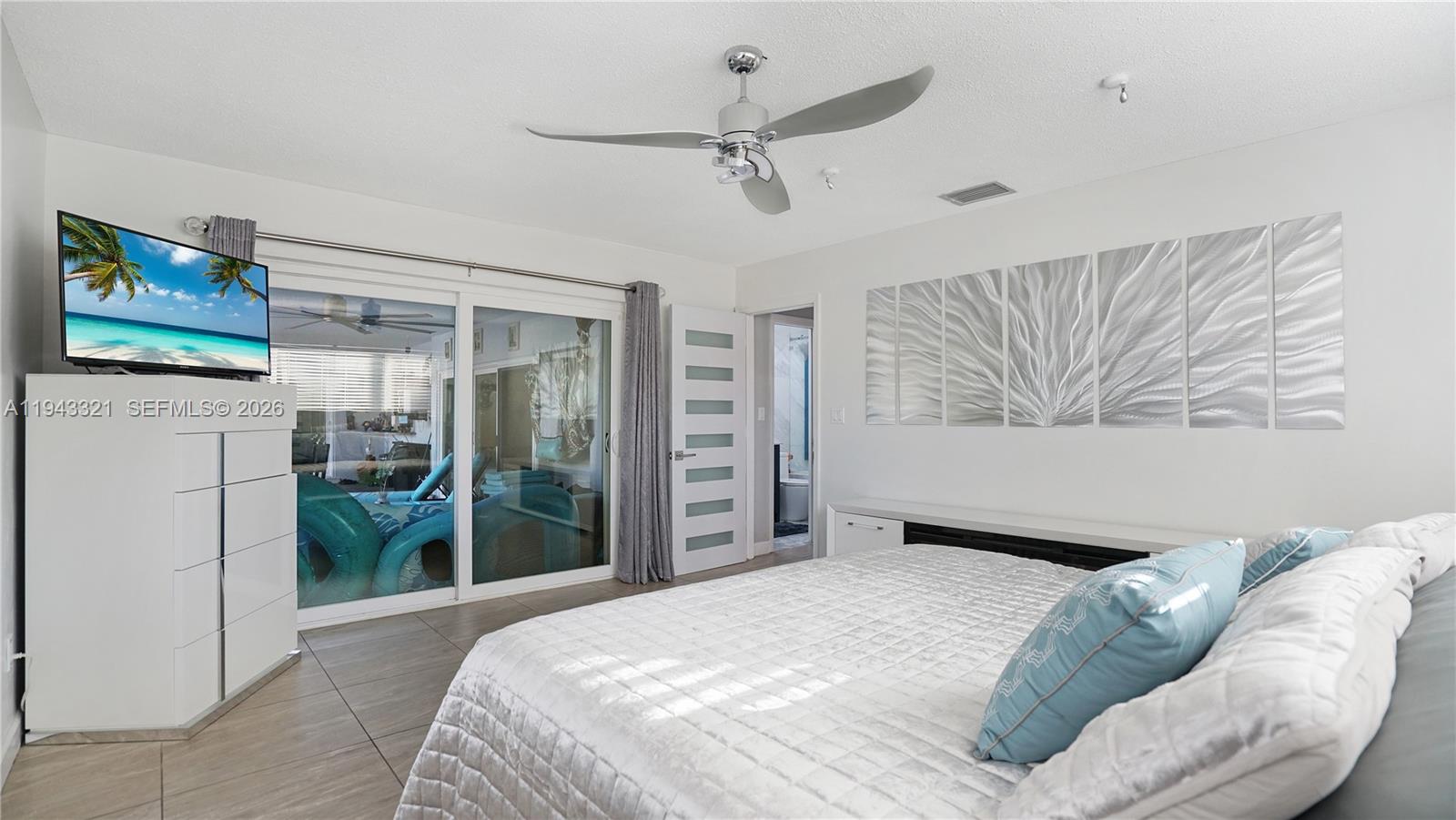 5921 Southwest 17th Street Plantation, FL 33317 - Photo 20 of 53 a bedroom with a bed and a flat screen tv