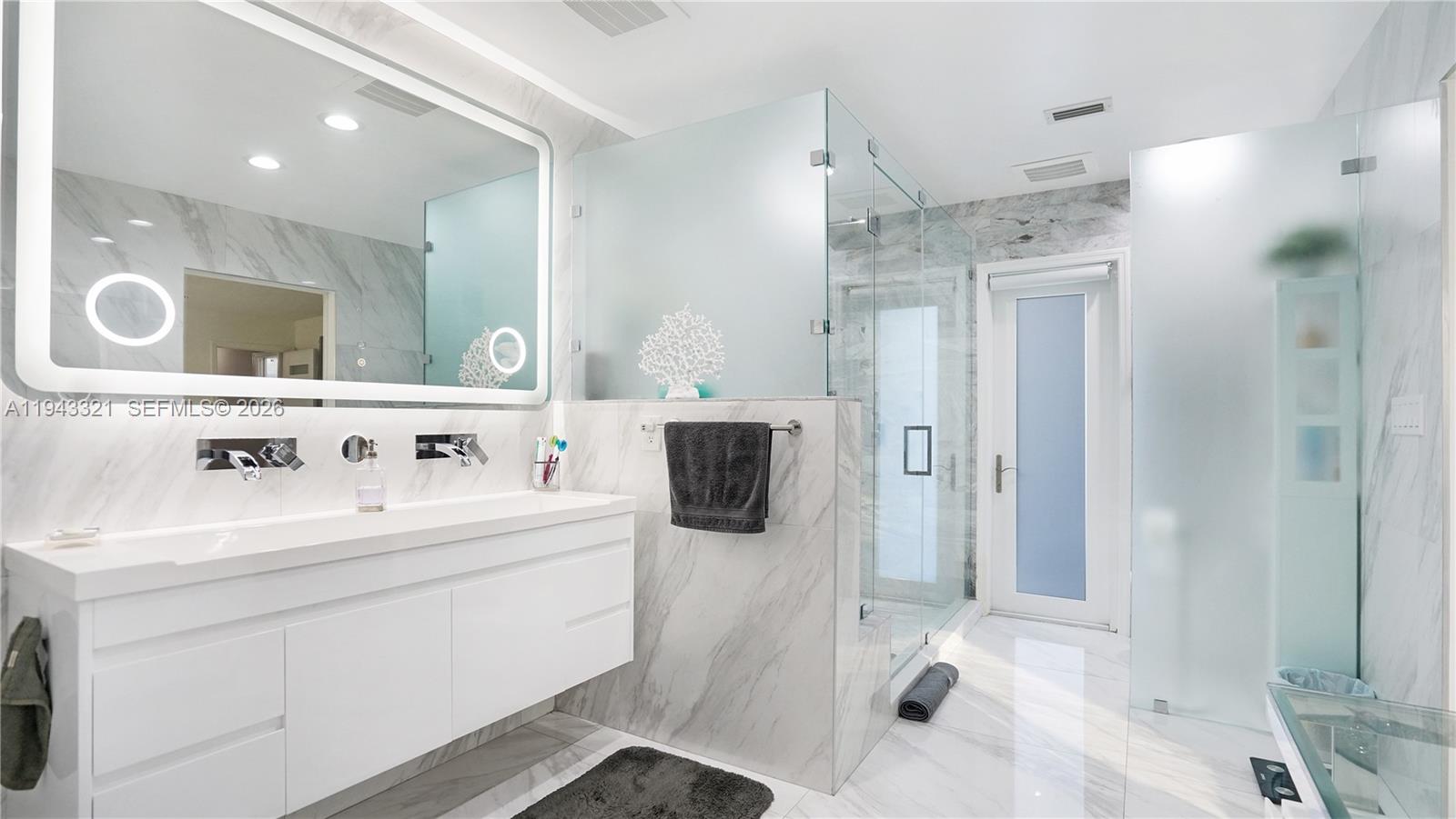 5921 Southwest 17th Street Plantation, FL 33317 - Photo 24 of 53 a bathroom with a double vanity sink a mirror and shower