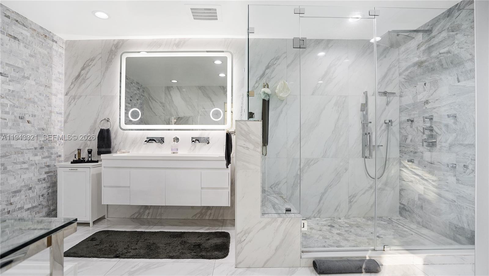 5921 Southwest 17th Street Plantation, FL 33317 - Photo 25 of 53 a bathroom with a sink a mirror and a shower