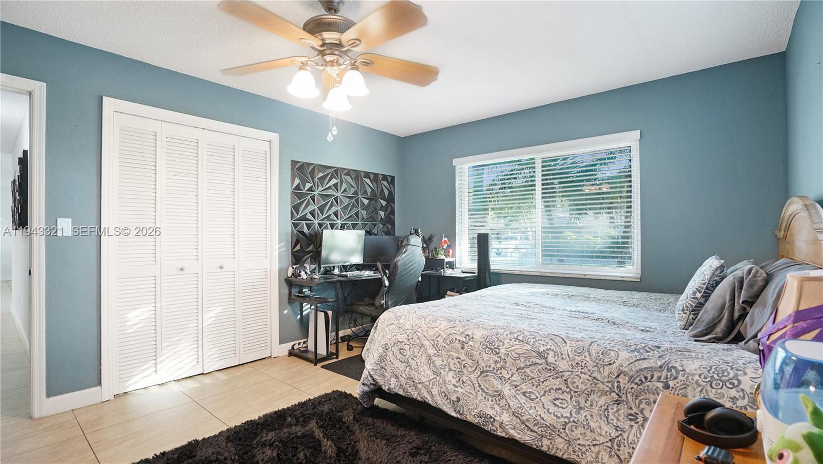 5921 Southwest 17th Street Plantation, FL 33317 - Photo 28 of 53 a bedroom with a bed and a chandelier