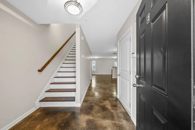 a view of a hallway with wooden floor and staircase