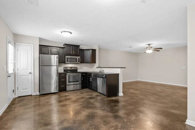 a kitchen with stainless steel appliances a refrigerator a stove a sink and dishwasher