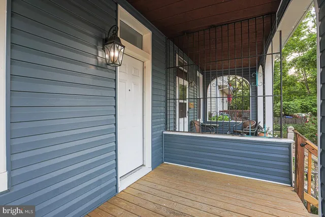 an empty room with wooden floor chandelier and windows