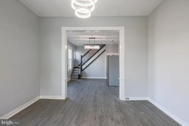 an empty room with wooden floor and a window