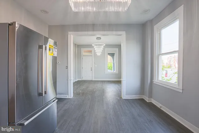 a view of a kitchen with wooden floor electronic appliances and windows