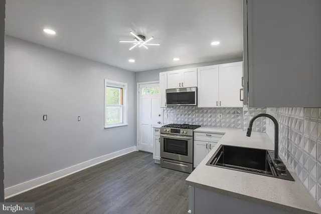a kitchen with sink a microwave and cabinets