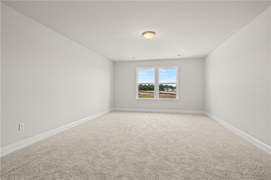 554 Hydrangea Street, Unit LOT 67 Seneca, SC 29678 - Photo 20 of 26 An airy secondary bedroom with plush carpeting offers tranquil views of the surrounding landscape.