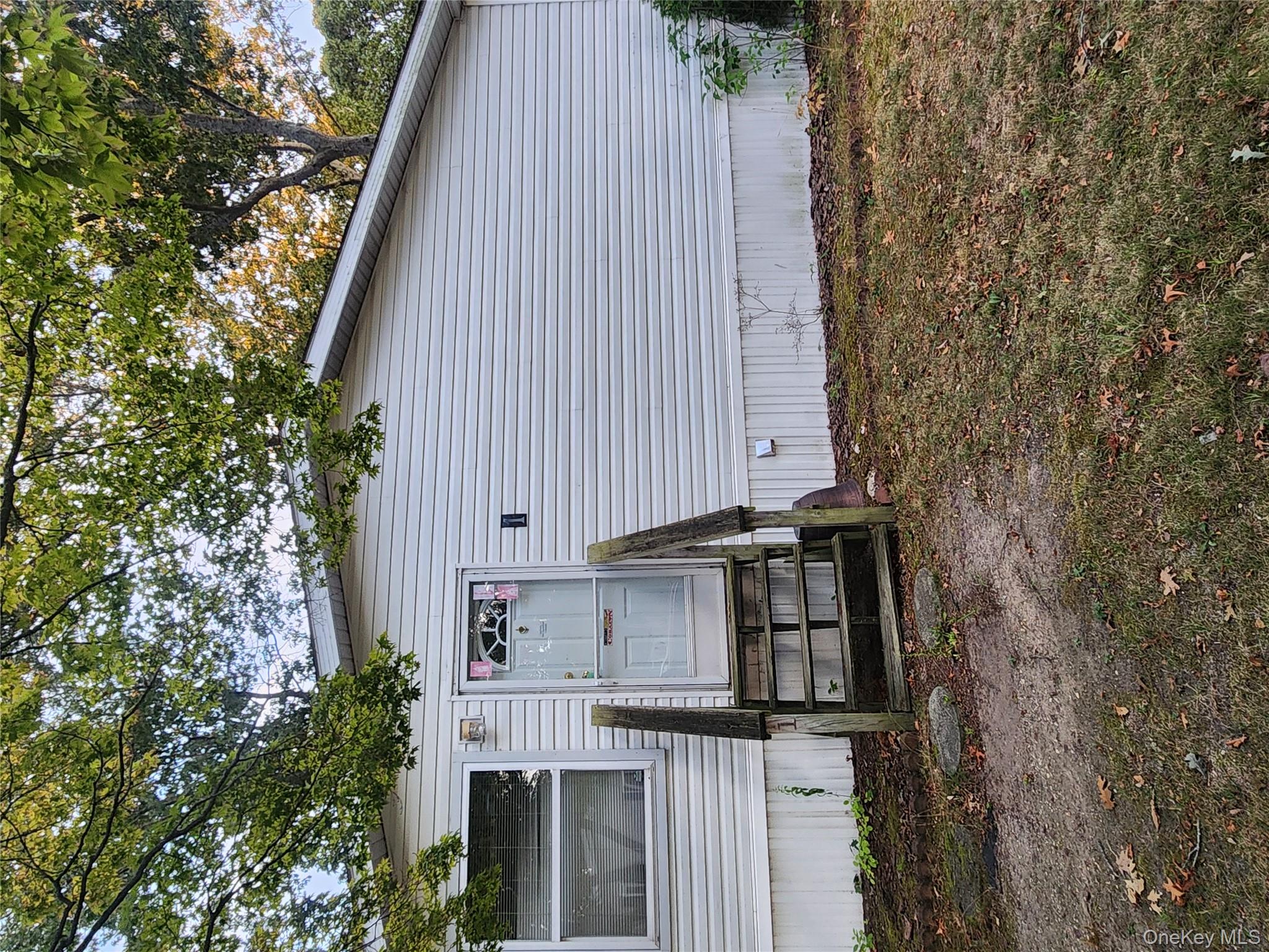 433 Mill Road, Unit #1 Riverhead, NY 11933 - Photo 1 of 1 Doorway to property featuring a lawn