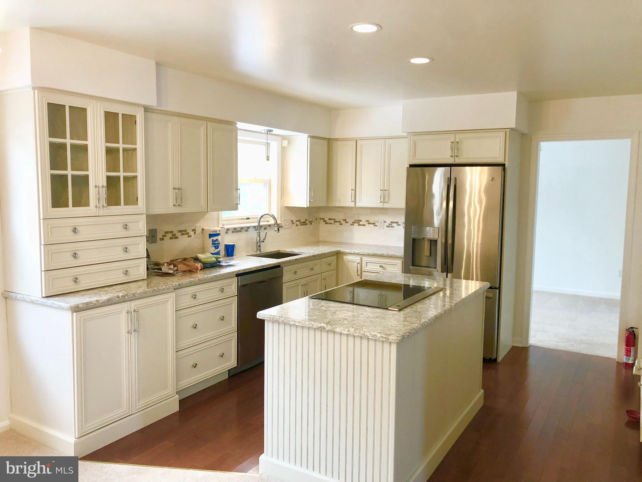 359 Freshfield Lane Arnold, MD 21012 - Photo 7 of 22 a kitchen with stainless steel appliances granite countertop a refrigerator a sink dishwasher a stove and white cabinets with wooden floor