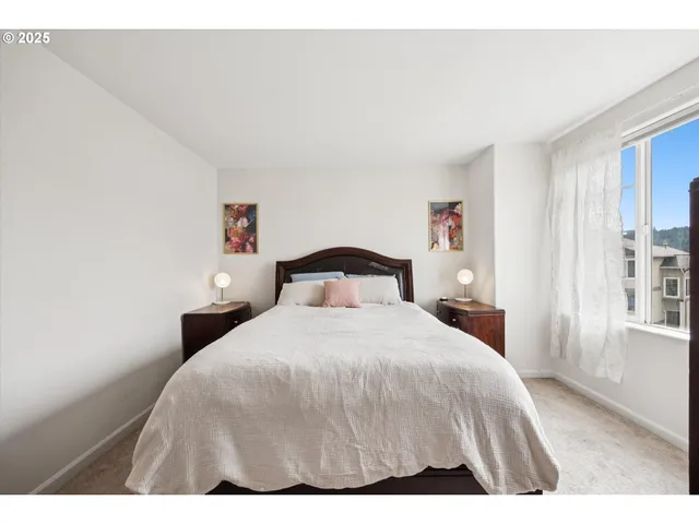 a bedroom with a bed and a large window