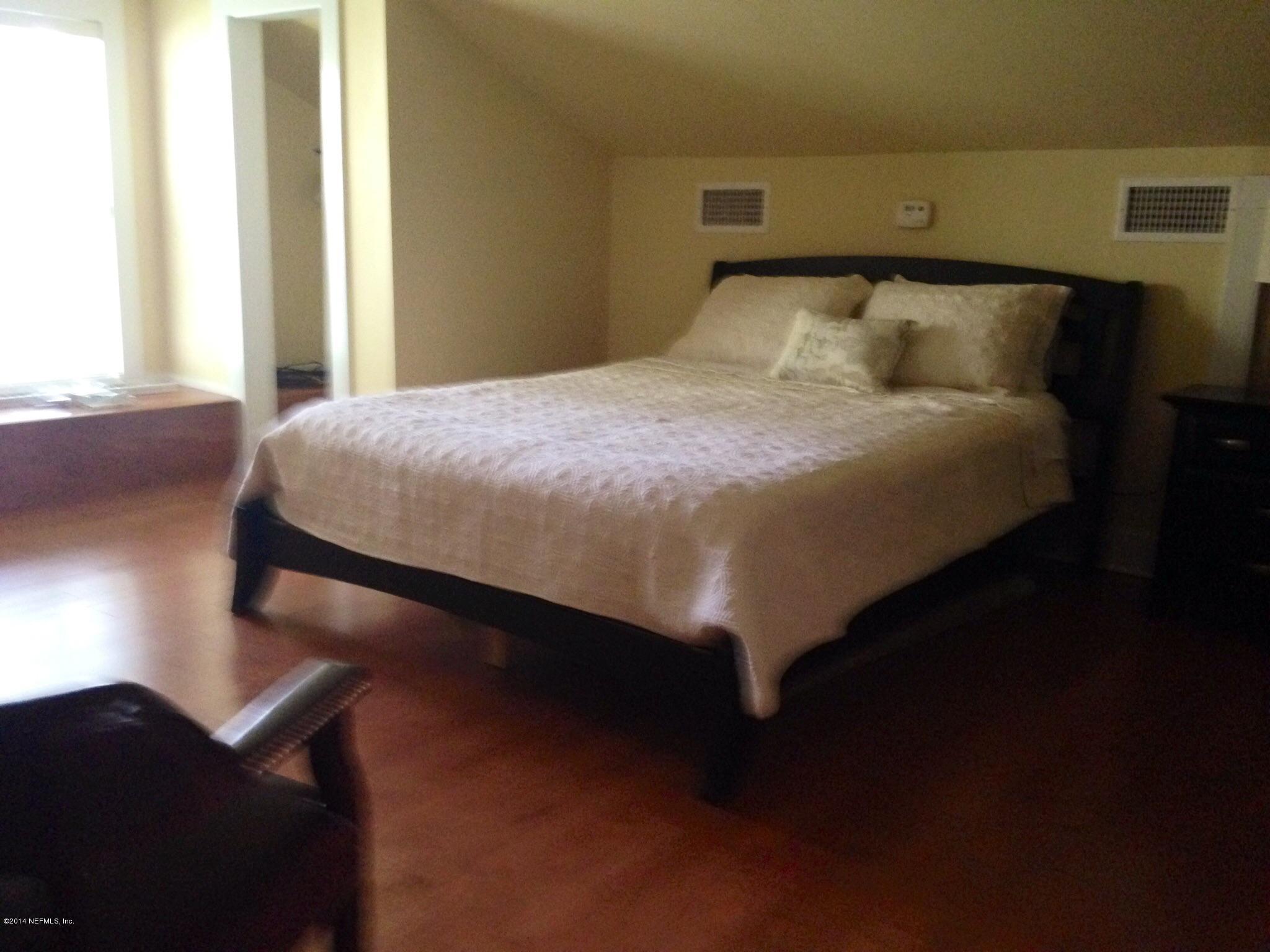 310 7th Street Atlantic Beach, FL 32233 - Photo 16 of 37 a bed sitting in a bedroom next to a window