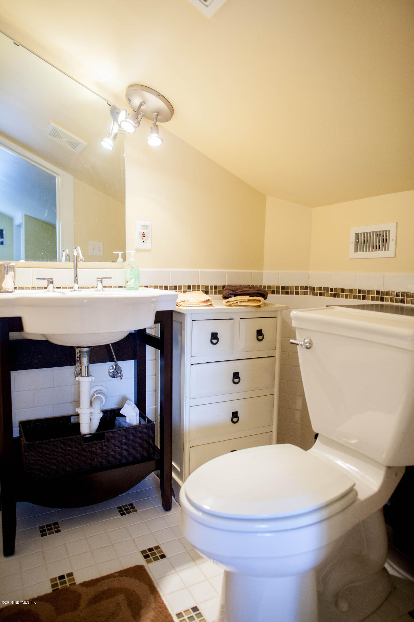 310 7th Street Atlantic Beach, FL 32233 - Photo 17 of 37 a bathroom with a sink a toilet and a mirror