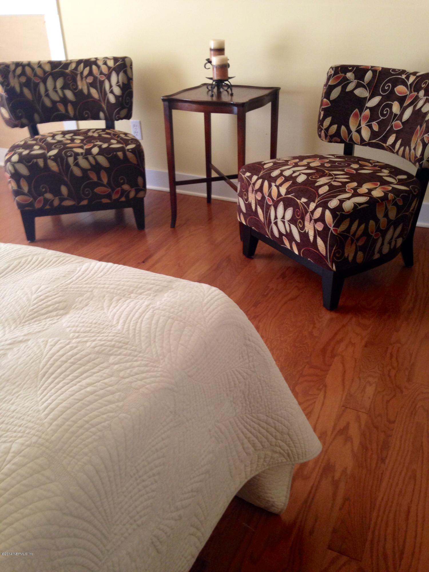 310 7th Street Atlantic Beach, FL 32233 - Photo 18 of 37 a large bed sitting in a bedroom next to a lamp