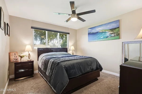 a bedroom with a bed and a painting on the wall