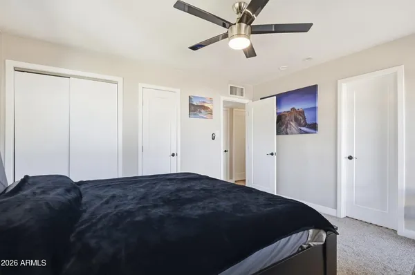a bedroom with a bed and a ceiling fan
