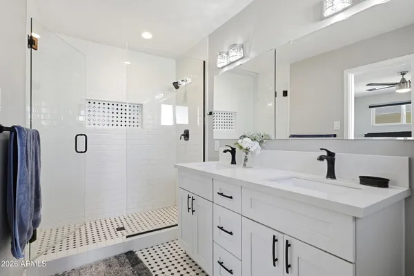 a bathroom with a sink a toilet a mirror and shower