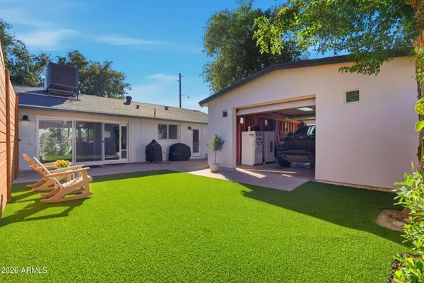 a view of a house with furniture and a yard