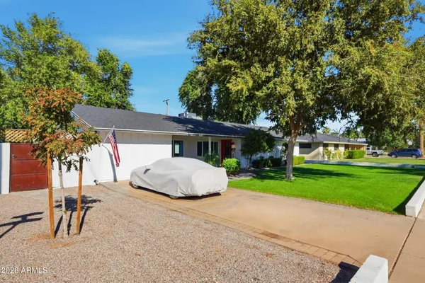 front view of a house with a yard and an trees