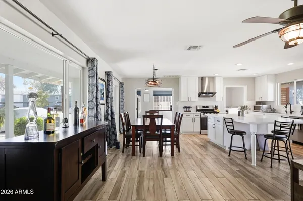 a dining room with furniture a chandelier and wooden floor