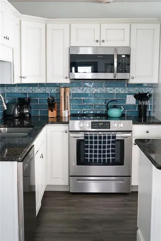 a kitchen with stainless steel appliances granite countertop a stove and a microwave