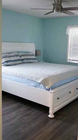a room with a wooden floor and potted plant on a table