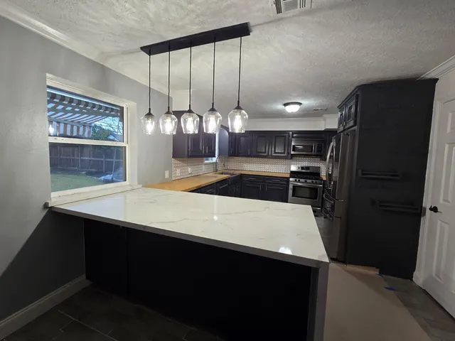 a kitchen with kitchen island a counter and a refrigerator