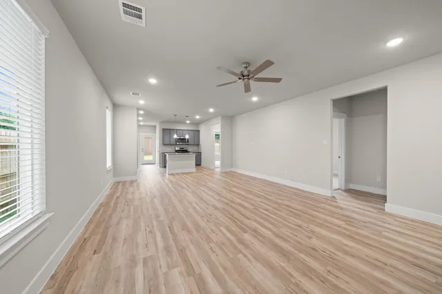 a view of empty room with wooden floor and window