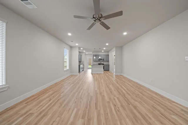 a view of empty room with wooden floor